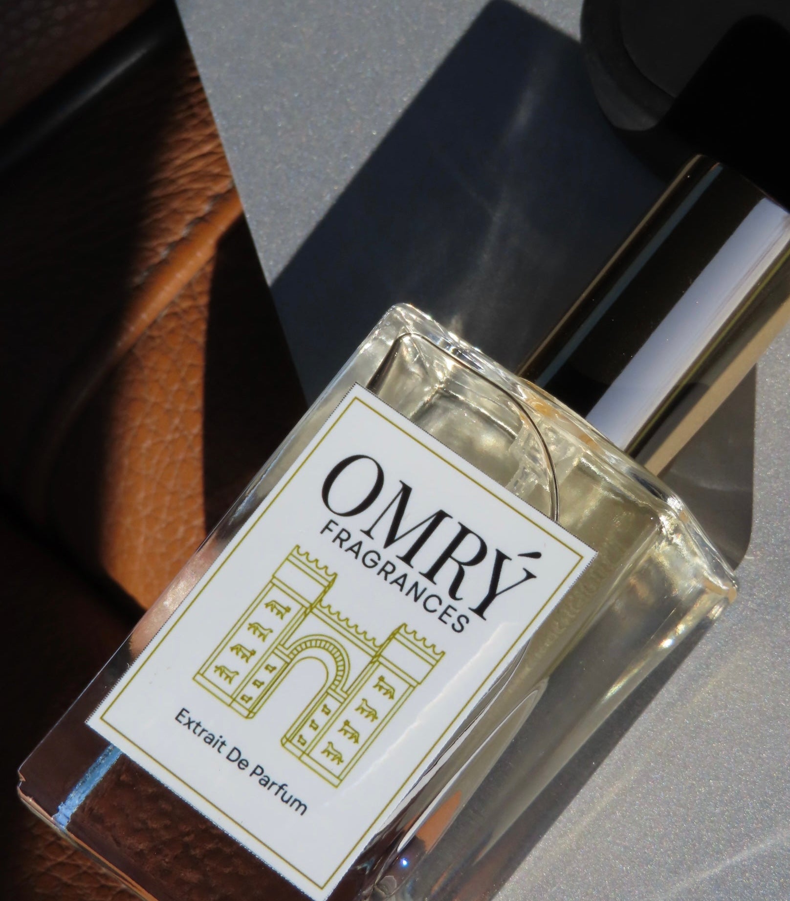 OMRY Fragrances perfume bottle on a textured surface
